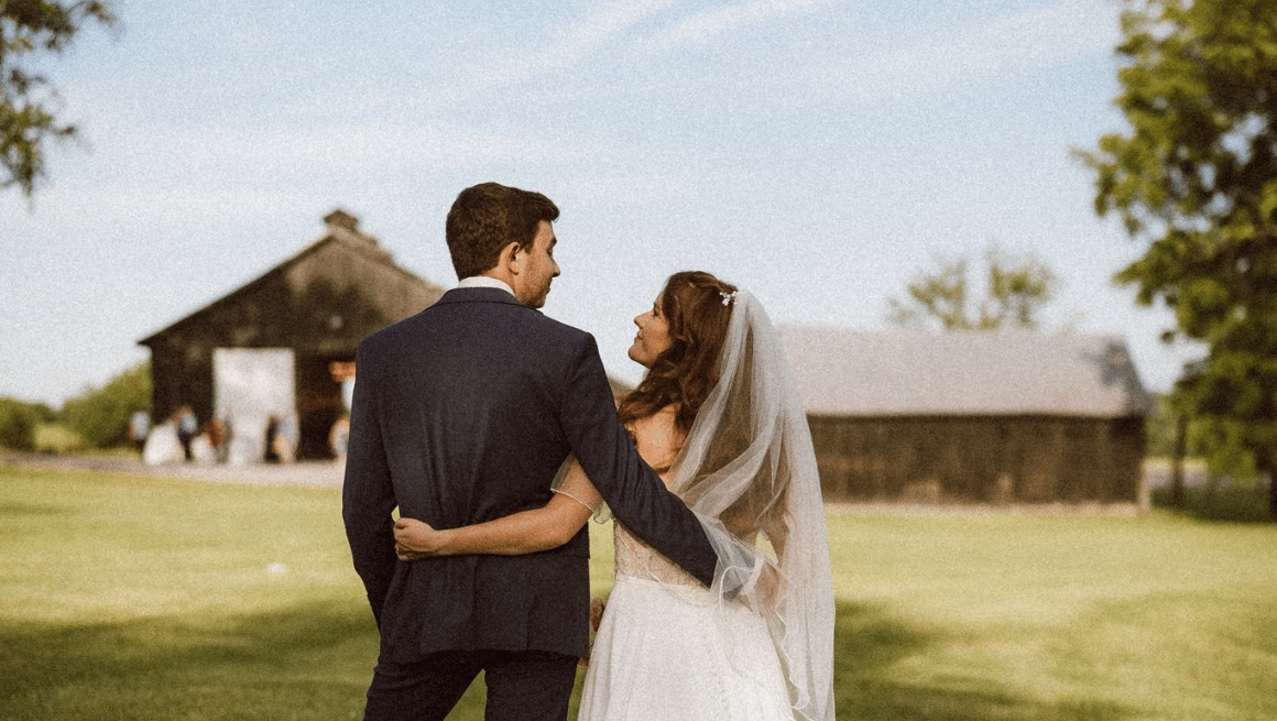 Couple in field overlooking their kentucky barn wedding - Warrenwood Manor